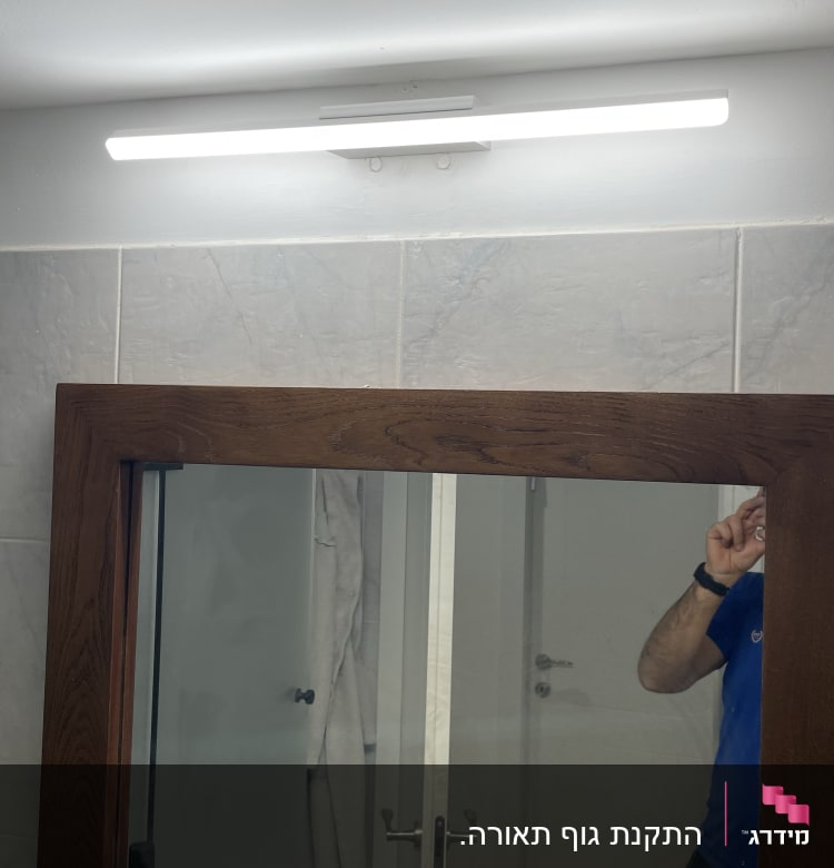 מנורת לד מותקנת מעל מראה בחדר אמבטיה